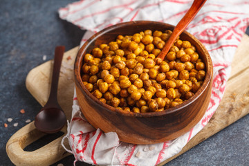 Healthy snack - baked spicy chickpeas in a wooden bowl. Healthy vegan food concept.