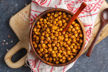 Healthy snack - baked spicy chickpeas in a wooden bowl, top view. Healthy vegan food concept.