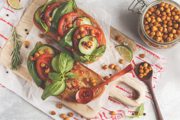 Open vegetarian sandwich with tomato, cucumber, fried chickpeas and basil, top view. Healthy vegan food concept.