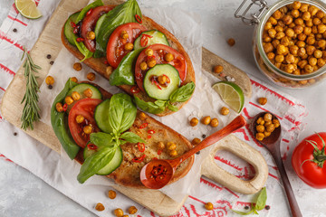 Open vegetarian sandwich with tomato, cucumber, fried chickpeas and basil, top view. Healthy vegan food concept.