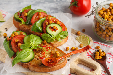 Open vegetarian sandwich with tomato, cucumber, fried chickpeas and basil. Healthy vegan food concept.