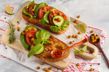 Open vegetarian sandwich with tomato, cucumber, fried chickpeas and basil. Healthy vegan food concept.