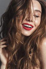 Fashion portrait of a cheerful shirtless curly brown hair woman