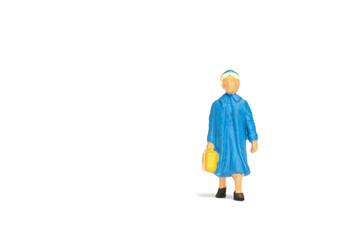 Miniature people ; Traveler holding a handbag standing on white background , Travel concept
