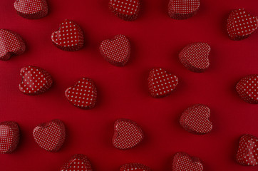 Red hearts candy pattern on deep red paper texture. Valentine day background.