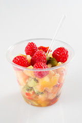 fruit salad in takeaway clear plastic cup in white background