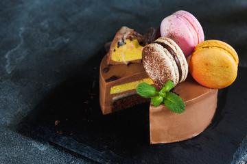 Chocolate cheesecake with banana filling decorated with macarons and toffee