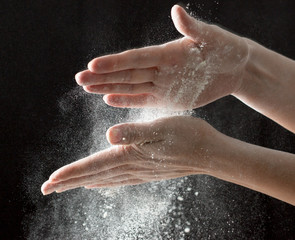 Obraz na płótnie Canvas hands with flour on a black background