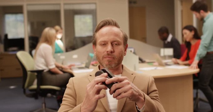 4K Businessman playing with the stapler, unable to hide his boredom during very boring conference call
