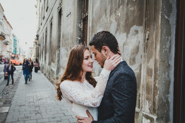 Wedding couple hugs in the old city. Stone walls of ancient town on background. Rustic bride with...