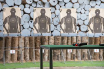 Shooting range indoor, short gun on the table prepare shoot with safety line