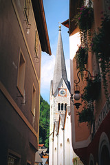 Tower in the European city of Hallstatt in Austria, a narrow street with balconies, a view of the historic church, an old chapel
