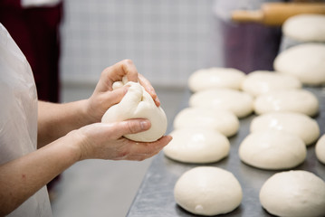 Female hands preparing dough for pizza closeup