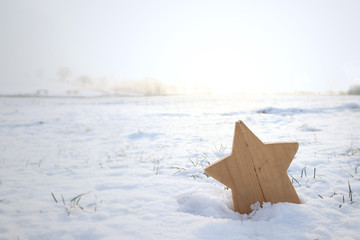 wooden star in a snow landscape