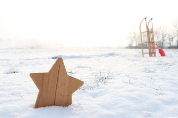 Wooden star and a sleigh in a winter snow scene landscape