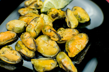 Mussels on a black plate.