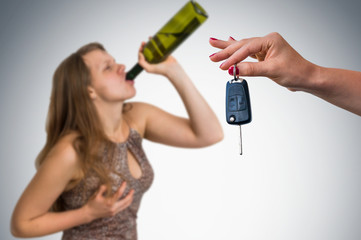 Woman drinking alcohol and her friend showing car keys
