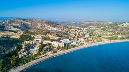 Fototapeta na wymiar Aerial bird's eye view of Pissouri bay, a village settlement between Limassol and Paphos in Cyprus. Panoramic view of the coast, beach, hotel, resort, hills, plain and building developments from above