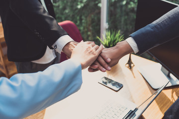 Obraz premium Putting hands of business office partnership colleagues and greeting join in working place collaboration meeting concept