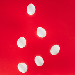 close up view of raw chicken eggs isolated on red