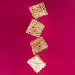 close up view of levitating toasts isolated on pink