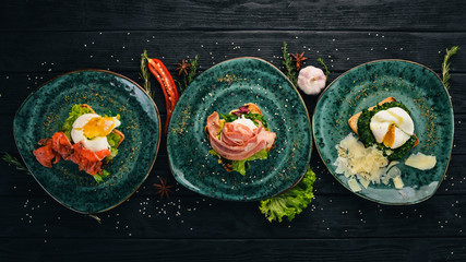 Poached egg with salmon, bacon and parmesan on a wooden background. Top view. Free space for your text.