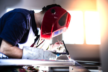 Man welding aluminum construction with TIG welder - obrazy, fototapety, plakaty