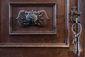 Old Keys in a Keyhole. Old rusty wooden door with keys.