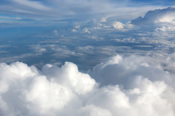 Naklejka na ściany i meble Aerial view on clouds and blue sky from airplane window