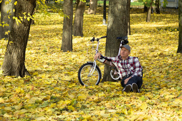 Fototapeta na wymiar Senior and his bicycle in autumn park.