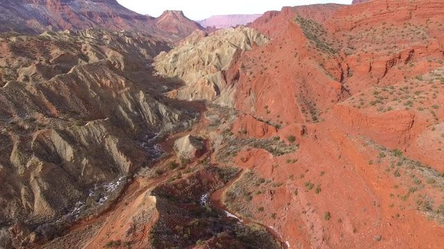Aerial view flying over colorful hills in Onion Creek in the Utah desert.