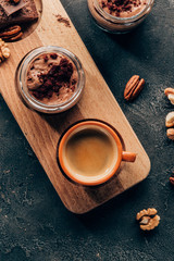 top view of sweet delicious chocolate dessert and cup of coffee on wooden board