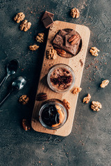 Fototapeta na wymiar top view of sweet tasty chocolate desserts with nuts on black