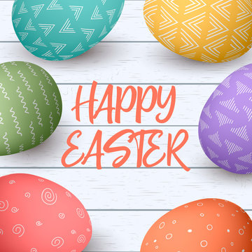 Happy Easter eggs frame with text. Colorful easter eggs on white wooden background.