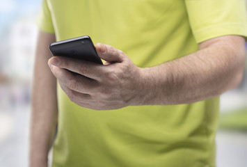 man's body with smartphone in his hand searching in it