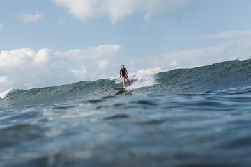 sportsman surfing wave on surf board in ocean