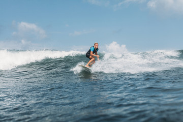 surfer riding wave on board in ocean