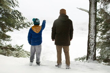 the boys are playing in the winter forest. walk in the winter forest of father and son