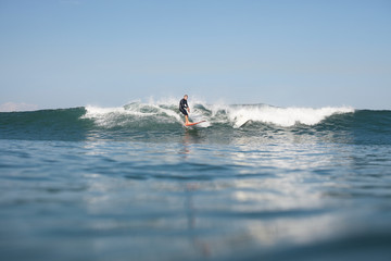 active man surfing wave on board in ocean