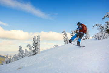 Snowboarder  jumps on the background of blue sky