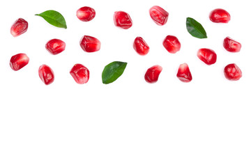 pomegranate seeds with leaves isolated on white background with copy space for your text. Top view. Flat lay pattern