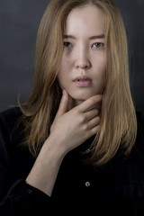 Beauty Woman Face. Portrait of beautiful Mongolian young female on black background. 