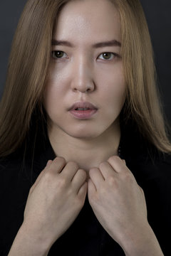 Beauty Woman Face. Portrait of beautiful Mongolian young female on black background. 