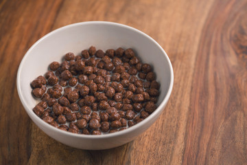 chocolate cereal breakfast in white bowl on wood table