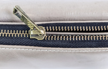 Golden brass zipper on a leather bag. selective focus.