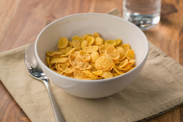 corn flakes in white bowl for breakfast on table