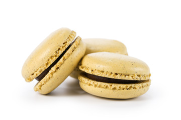 three yellow macarons with jam isolated on white
