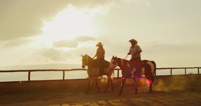 Couple horseback riding at sunset