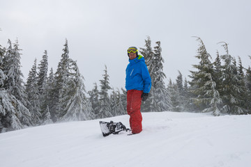 Fototapeta na wymiar Joyful snowboarder relaxes during freeride in a hard conditions