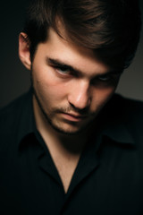 young brunette guy on a dark background